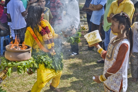 PANGKOR ISLAND, MALAYSIA - February 17, 2011 Masi Magam festival  Some women carry, with bare hands, pot of earth containing red or inflamed embersのeditorial素材
