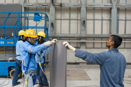 SINGAPORE â€“ february 25, 2011 : workers installing glass plates on a new building
