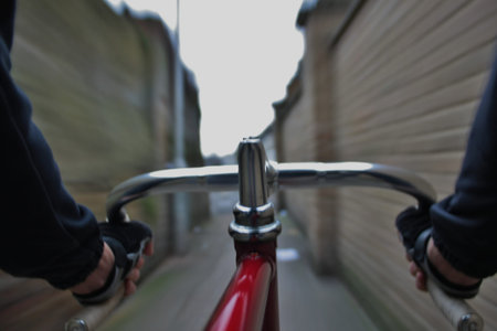 Long exposure taken from a camera fixed  on a fixed gear bicycle  In the forehand a close up of the handlebar の写真素材