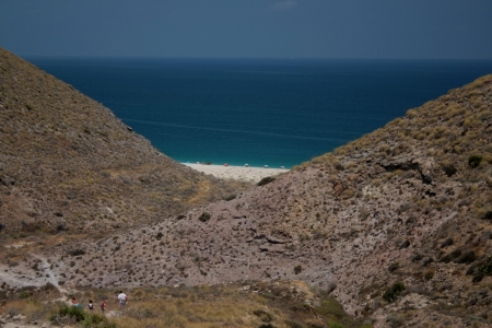 A view of a portion of sea between two dry hills in a sunny day of summerの写真素材