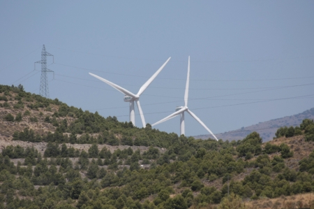 Wind turbines beyond a hill in Almeria, Spainの写真素材
