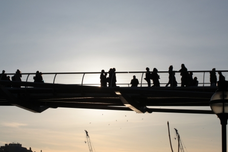 London, United Kingdom  March 19, 2011  Silhouettes of pedestrians walking on a pedestrian bridge  Fosters Millennium Bridge のeditorial素材