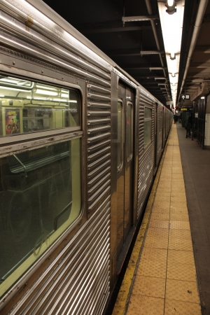 New York, NY, USA  January 19, 2013  Close up of a metal train of the Subway line 1, New York City, USA, beside the Platform with closed doors  On the platform are visible the yellow security line and the electric neon light for the station lightening  のeditorial素材
