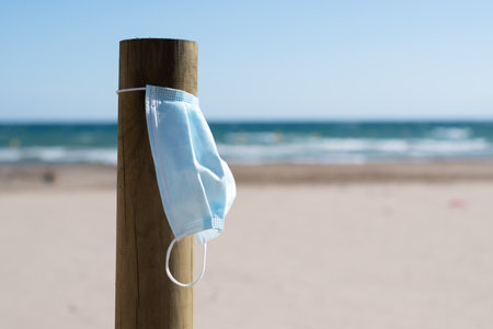 Surgical mask hung on the beachの写真素材