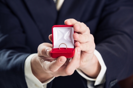 Close up of man holding wedding ring and gift box. Close up of man holding wedding ring and gift box.