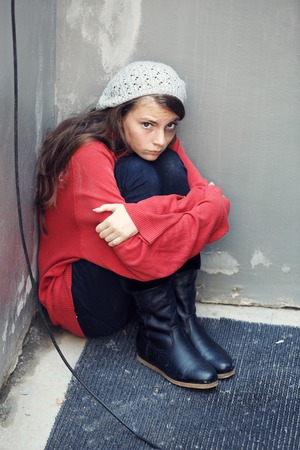 Homeless girl sitting on the floorの写真素材