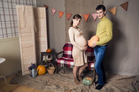 Husband and a pregnant wife with pumpkinの写真素材