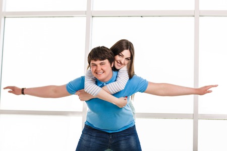Young playful involved couple posing as flyingの写真素材