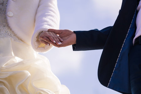 Bride and groom holding hands outdoorsの写真素材