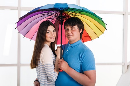 Happy smiling couple under a umbrellaの写真素材