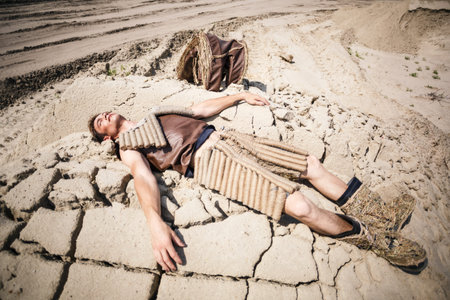 Young man lying on the sandの写真素材