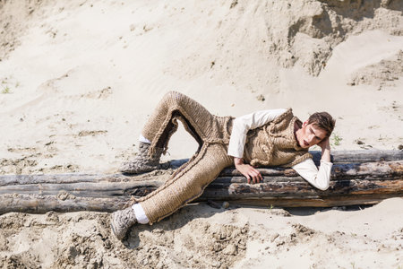 Fashion of young man laying on logの写真素材