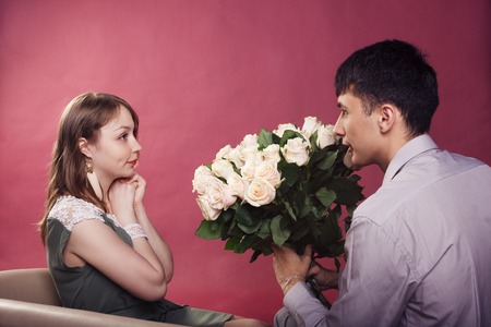 Beautiful young smiling couple in love embracing indoorの写真素材