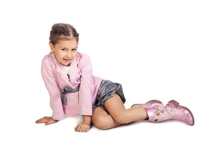 Little girl sitting on the floor, smiling and looking at the cameraの写真素材