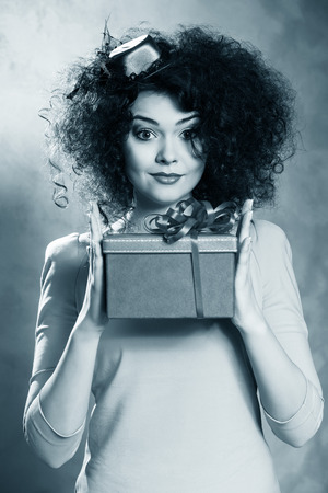 Portrait of a beautiful happy female with red box in handsの写真素材