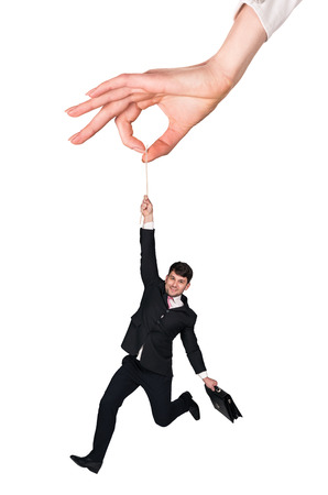 Businessman hanging on a rope in blue sky backgroundの写真素材