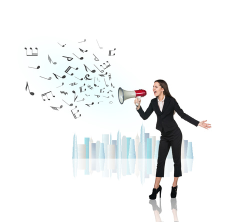 Business woman sing with megaphone with flying notesの写真素材
