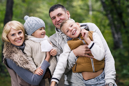 Close up portrait of a young family in the autumn parkの写真素材
