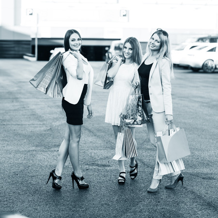 Group of girls after shopping on a parkingの写真素材