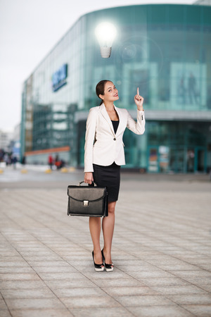Full length portrait of a business woman walking with briefcase near office building. Idea conceptの写真素材