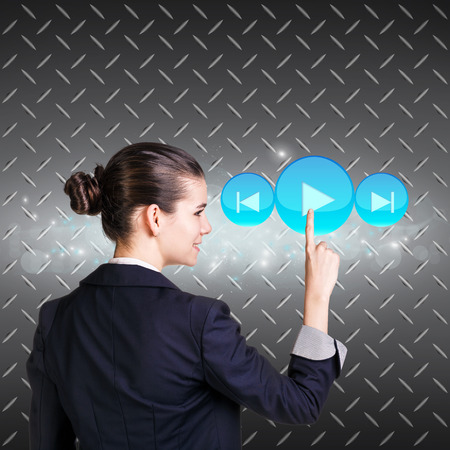 Smiling woman pressing digital button. Metal backgroundの写真素材