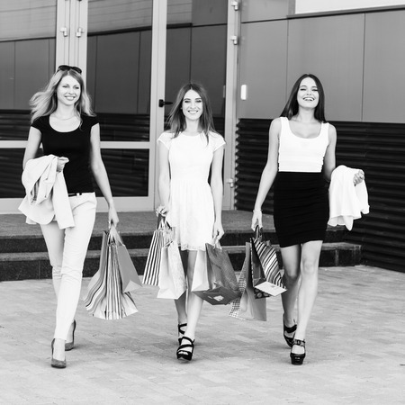 Three young women walking on a summer day in the cityの写真素材
