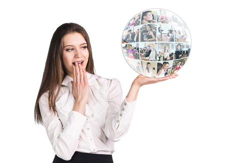 Surprised young woman present a collage sphere on the open hand palm, over white backgroundの写真素材