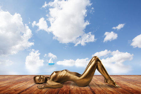 Young pretty woman posing naked on the pier.の写真素材