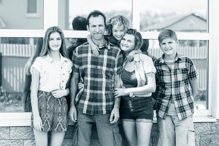 Big happy family stands beside their houseの写真素材