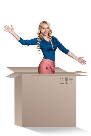 Beautiful girl inside a cardboard box makes surprise on the white backgroundの写真素材