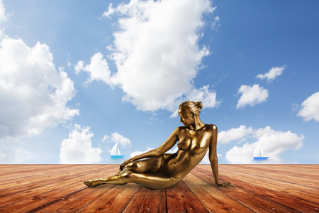 Young pretty woman posing naked on the pier.の写真素材
