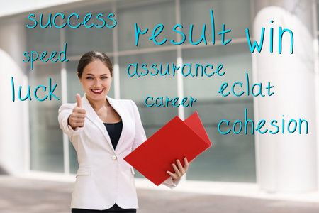 Happy young business woman with a folder at the office buildingの写真素材