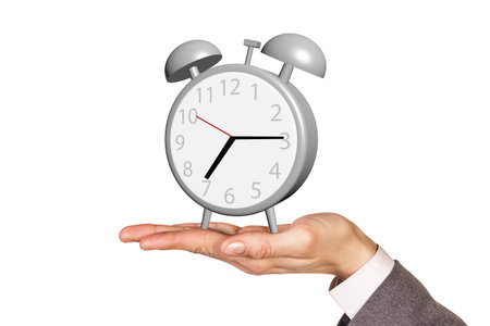 Alarm clock stands on the human palm isolated on white background