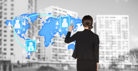 Businesswoman stands near map with icons on the city background. の写真素材
