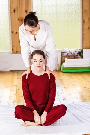 Young woman getting traditional thai stretching massage by therapistの写真素材