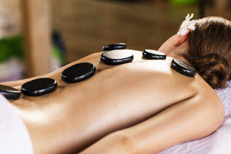 Young beautiful woman lying on massage table and waiting therapistの写真素材