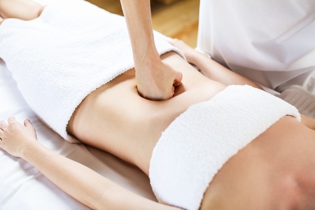 Beautiful young woman having visceral massage. Close-upの写真素材