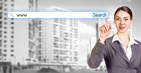 Businesswoman stands on the street and searching in internetの写真素材