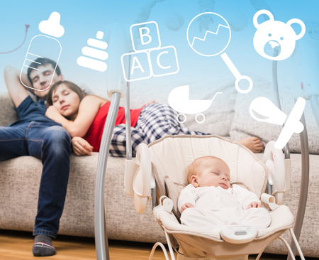 Newborn sleeping in baby swing and tired parents backgroundの写真素材