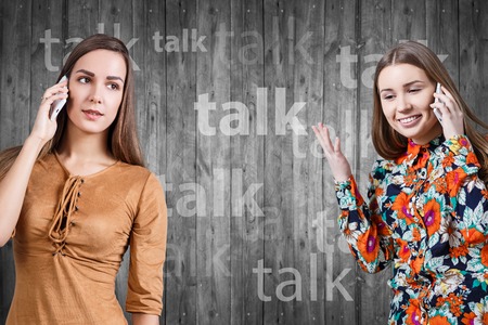 Young women speaking on phone isolated on whiteの写真素材