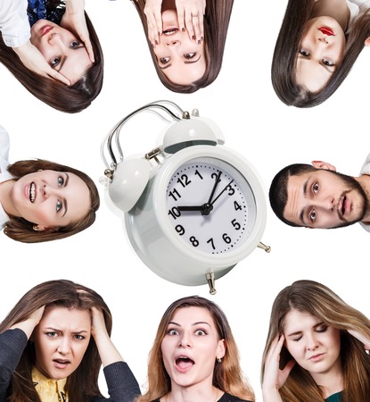 Women with a headache and ringing alarm clock isolated on whiteの写真素材