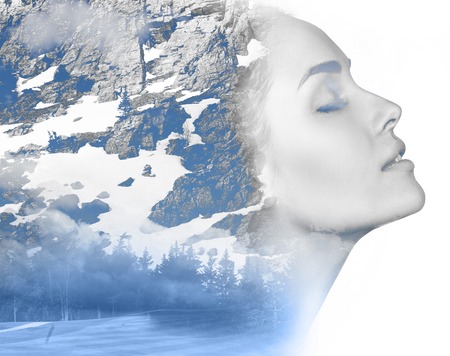 Double exposure portrait of attractive girl combined with photograph of snowy mountainの写真素材