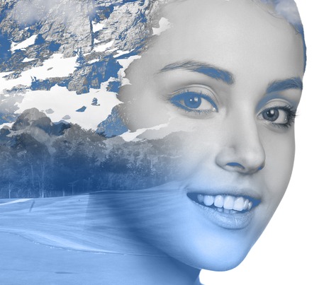 Double exposure portrait of attractive girl combined with photograph of snowy mountainの写真素材