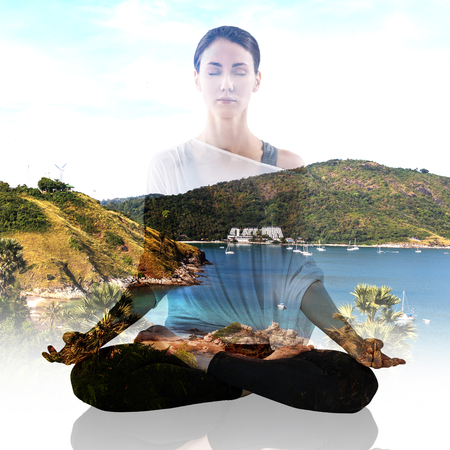 Double exposure portrait of woman in lotus position and natureの写真素材