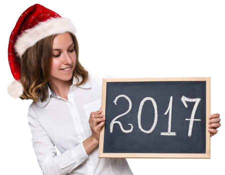 Young woman with xmas red hat showing chalkboard with year date isolated on whiteの写真素材