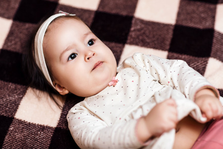 Baby girl lying on the checkered plaidの写真素材