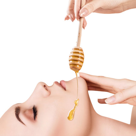 Beautiful woman with honey on face.の写真素材