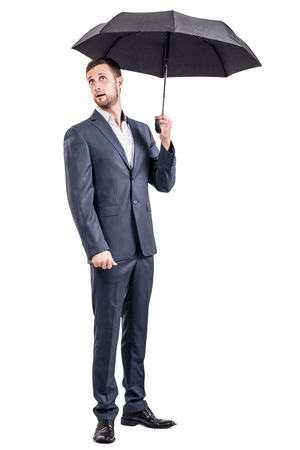 Surprised businessman holding an umbrella.の写真素材