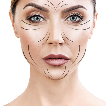 Beautiful woman face with massaging arrows on faceの写真素材