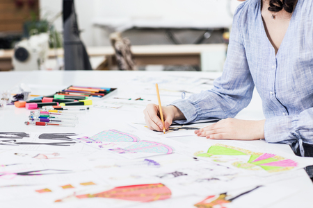 Young designer draws sketches of clothes.の写真素材